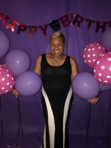 Woman posing with birthday decorations